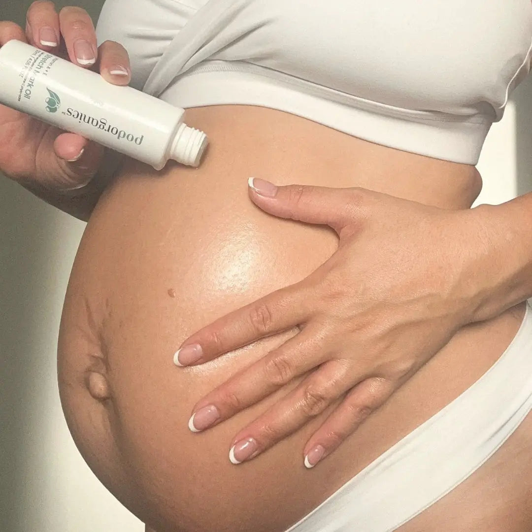 Mum-to-be massaging Pod Organics Stretch Mark Oil onto her belly