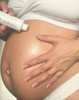 Mum-to-be massaging Pod Organics Stretch Mark Oil onto her belly